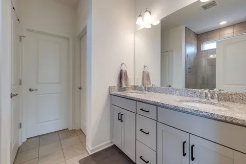 a bathroom with a granite countertop sink two mirror and a vanity