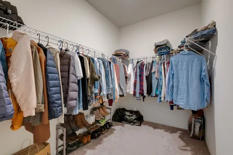 a view of walk in closet with clothes