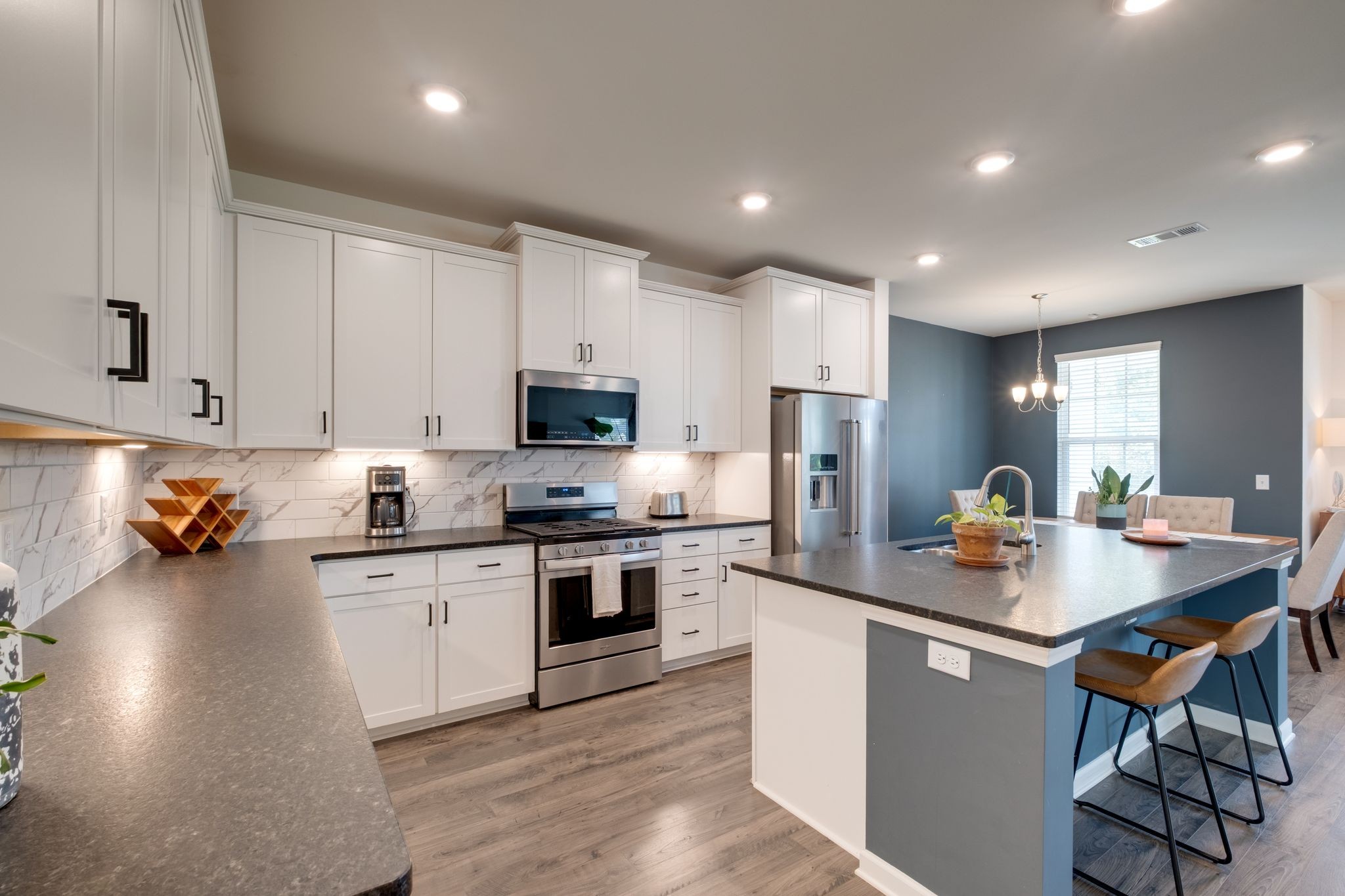 3611 Hoggett Ford Road Hermitage, TN 37076 - Photo 9 of 34 a kitchen with stainless steel appliances granite countertop a stove top oven a sink dishwasher a dining table and chairs with wooden floors