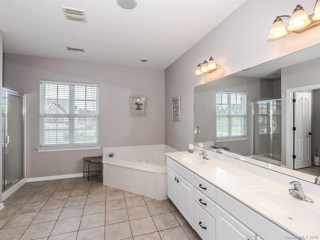 2002 Spanish Moss Road Indian Trail, NC 28079 - Photo 20 of 28 a spacious bathroom with a double vanity sink a mirror and a bathtub