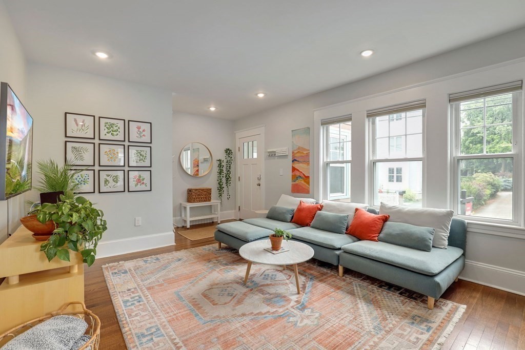 a living room with fireplace furniture and a large window