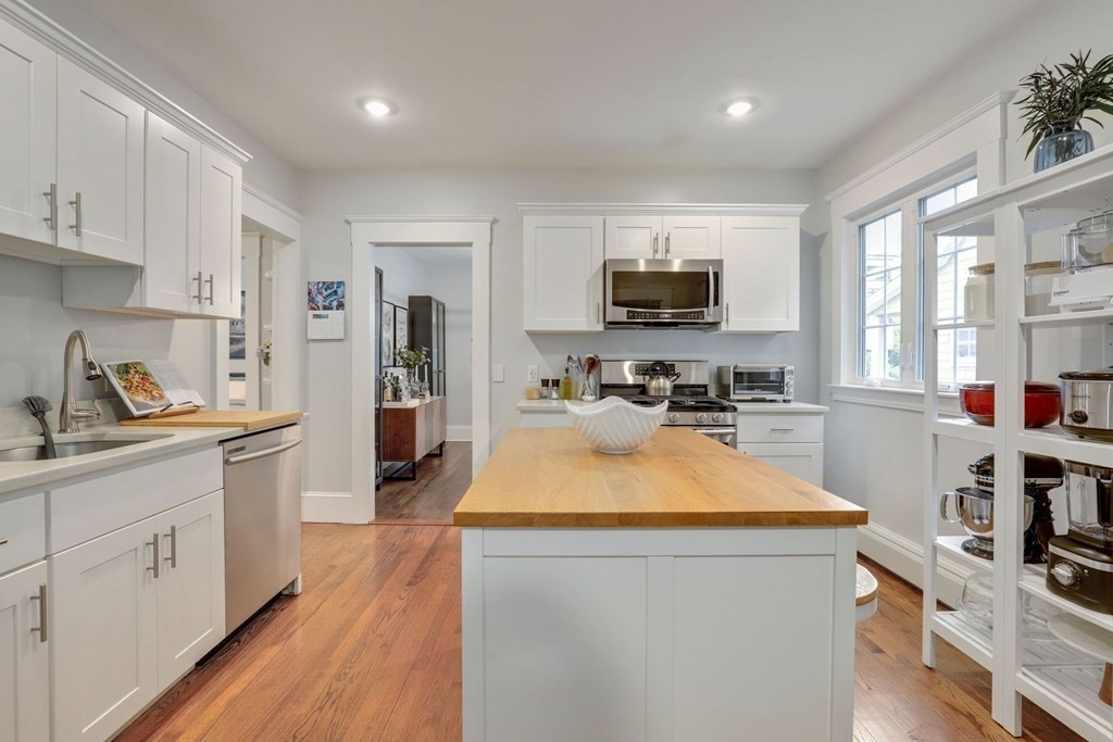 71-73 Brookley Road, Unit 1 Boston, MA 02130 - Photo 13 of 28 a large kitchen with kitchen island a sink dishwasher a stove and a refrigerator with wooden floor