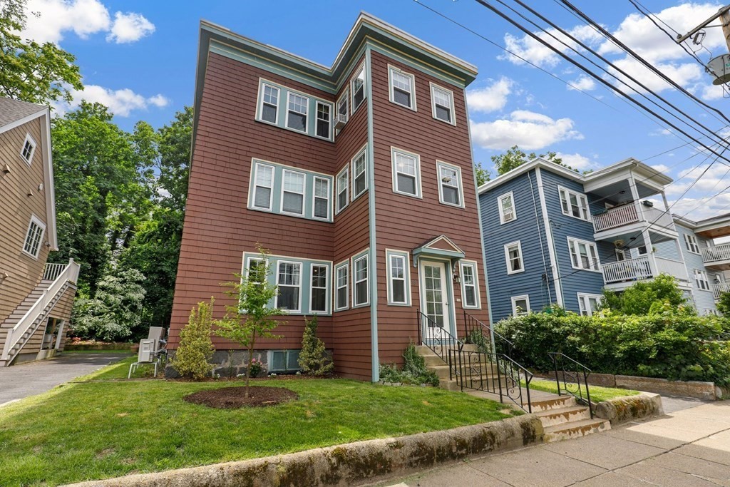 71-73 Brookley Road, Unit 1 Boston, MA 02130 - Photo 27 of 28 a view of a brick building next to a yard