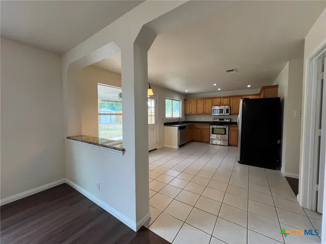a view of a kitchen with a sink and a refrigerator