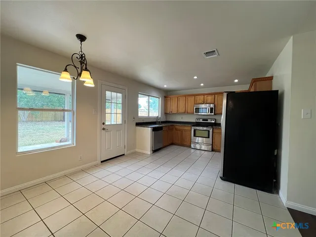 a kitchen with stainless steel appliances granite countertop a refrigerator and a sink