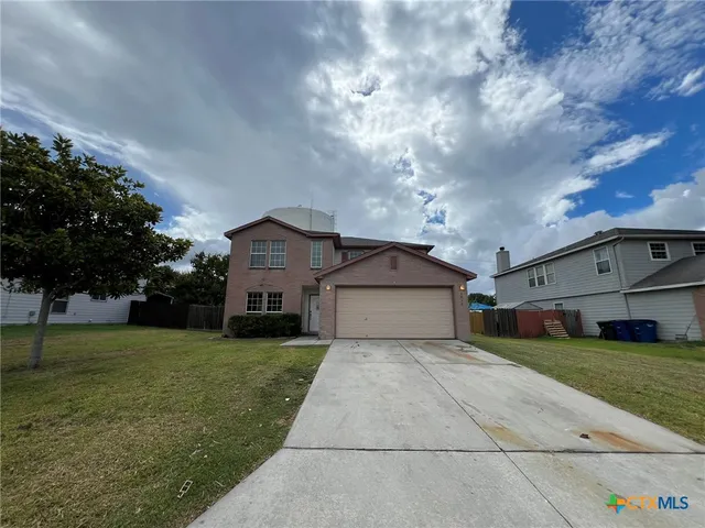 a view of a house with a yard and large trees