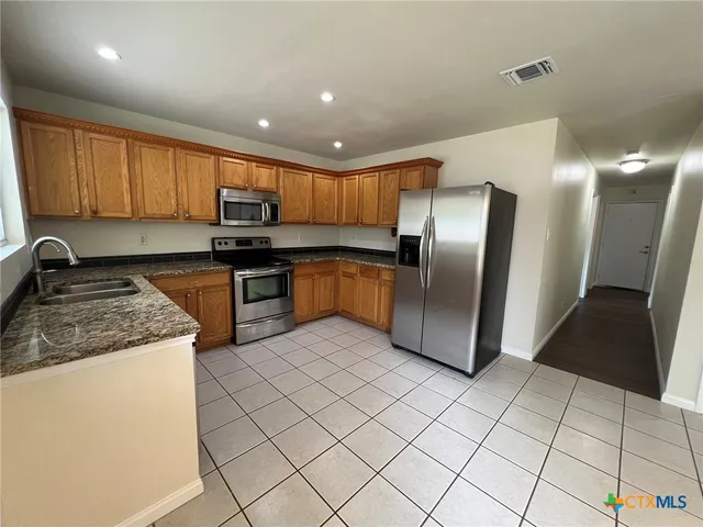 a kitchen with stainless steel appliances granite countertop a refrigerator sink and cabinets