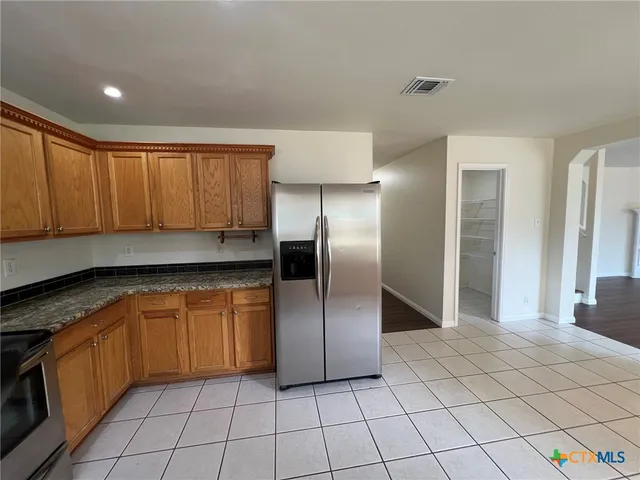 a kitchen with stainless steel appliances granite countertop a refrigerator and a sink