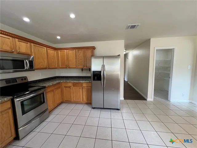 a kitchen with stainless steel appliances granite countertop a refrigerator and a sink
