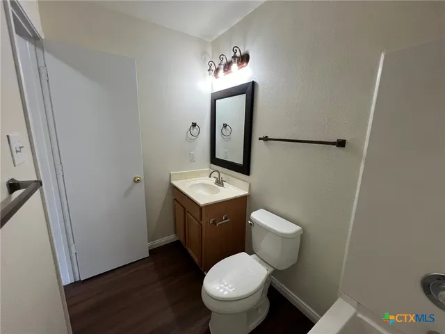 a bathroom with a toilet a sink and mirror