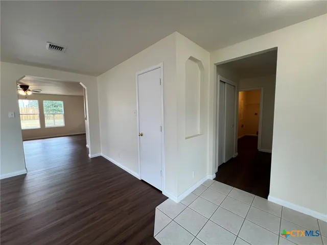 a view of a hallway with wooden floor and closet