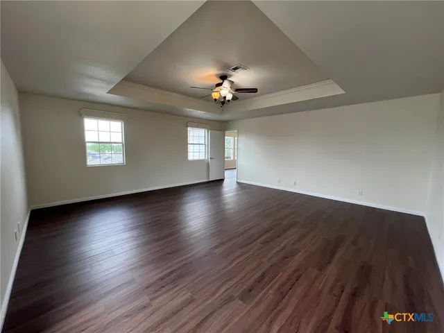 a view of a livingroom with wooden floor and a ceiling fan