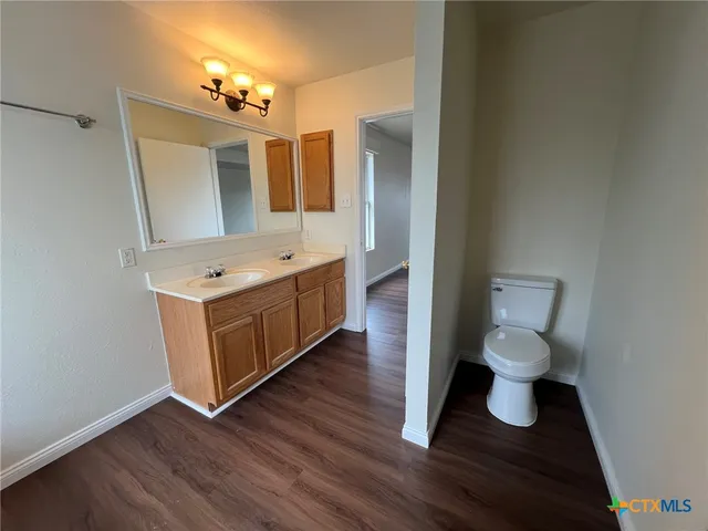 a bathroom with a toilet sink and mirror