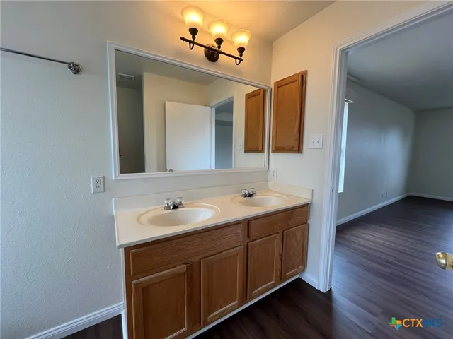 a bathroom with a double vanity sink and mirror