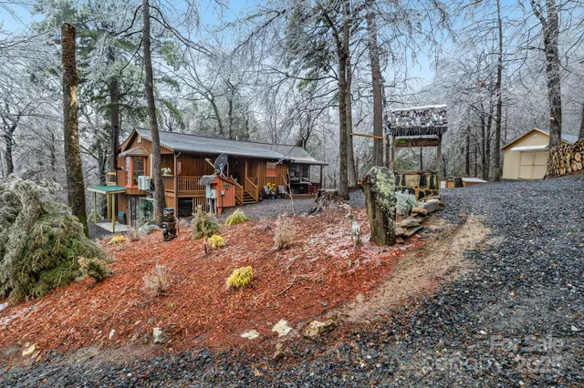 a backyard of a house with wooden fence and large trees