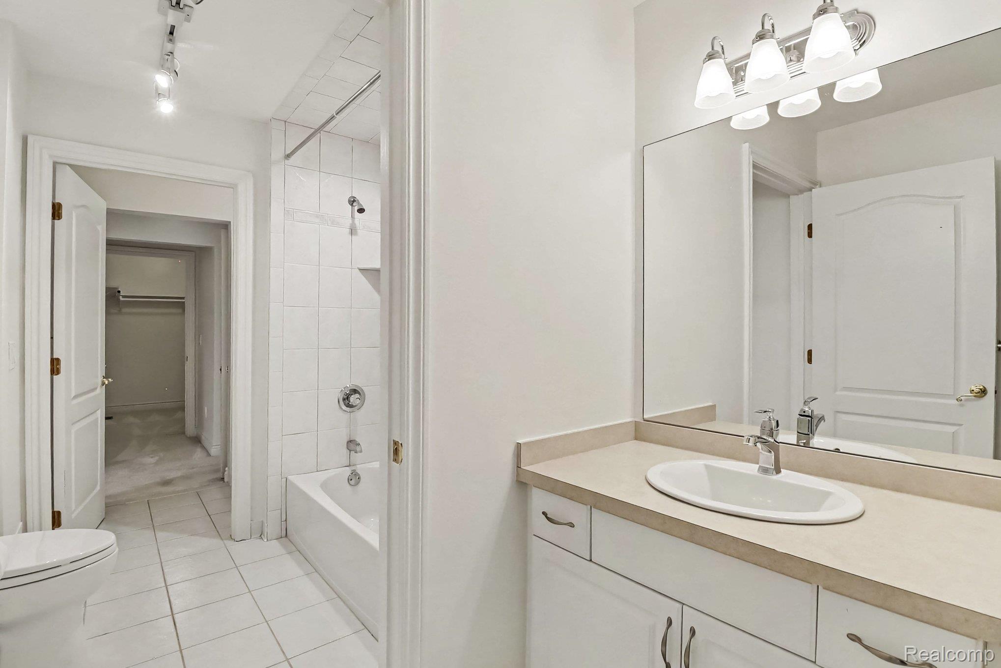 4875 Green Meadow Lane Rochester, MI 48306 - Photo 39 of 60 Full bathroom with white tiled flooring, a built-in vanity with a composite countertop, a drop-in sink, and a combination tub/shower
