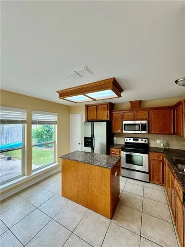 a kitchen with stainless steel appliances granite countertop a sink and a stove
