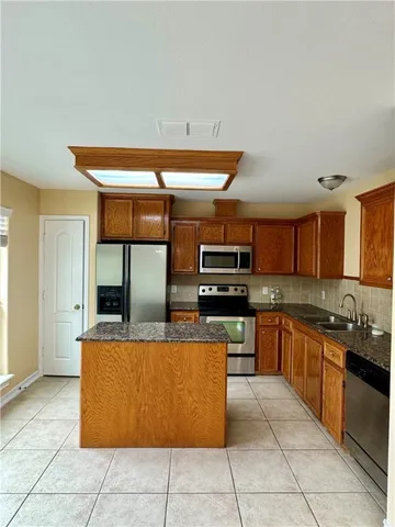a kitchen with stainless steel appliances granite countertop a sink and a counter top space