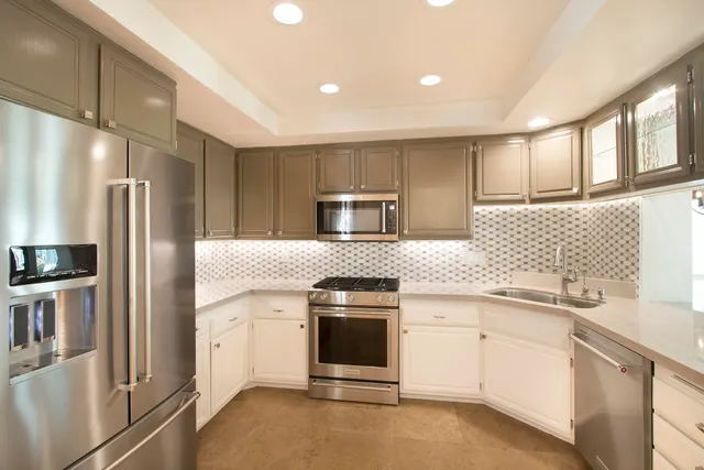 a kitchen with stainless steel appliances granite countertop a stove a refrigerator and a sink