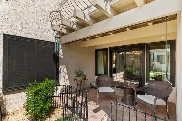 a view of a patio with couches table and chairs and potted plants