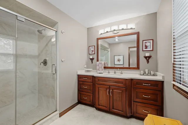 a bathroom with a granite countertop sink mirror and a shower