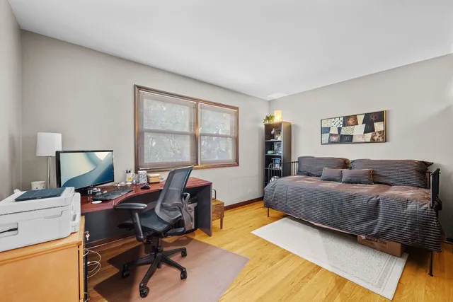 a bedroom with a bed and wooden floor