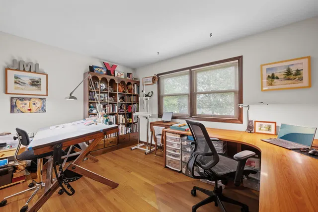 a view of a workspace with furniture and a window