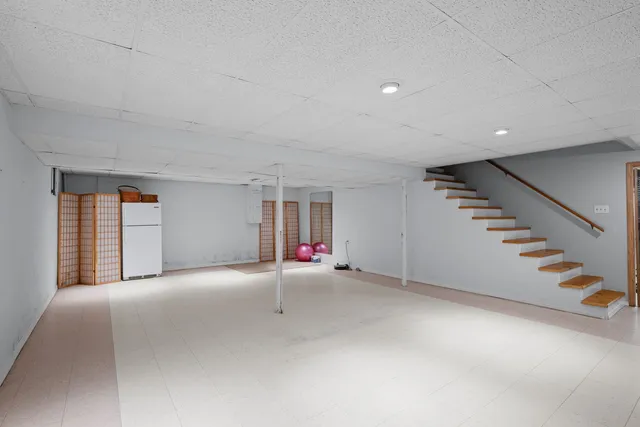 a view of an empty room with stairs and windows