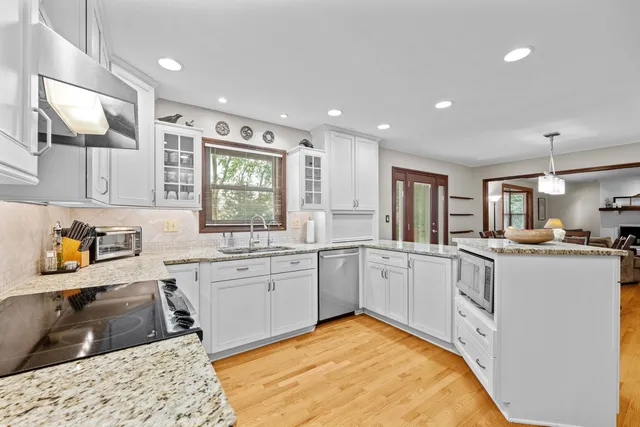 a large white kitchen with cabinets a sink and appliances