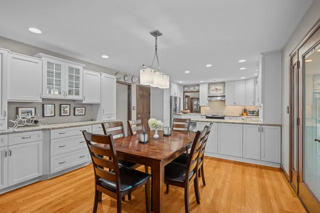 a kitchen with a dining table chairs and cabinets