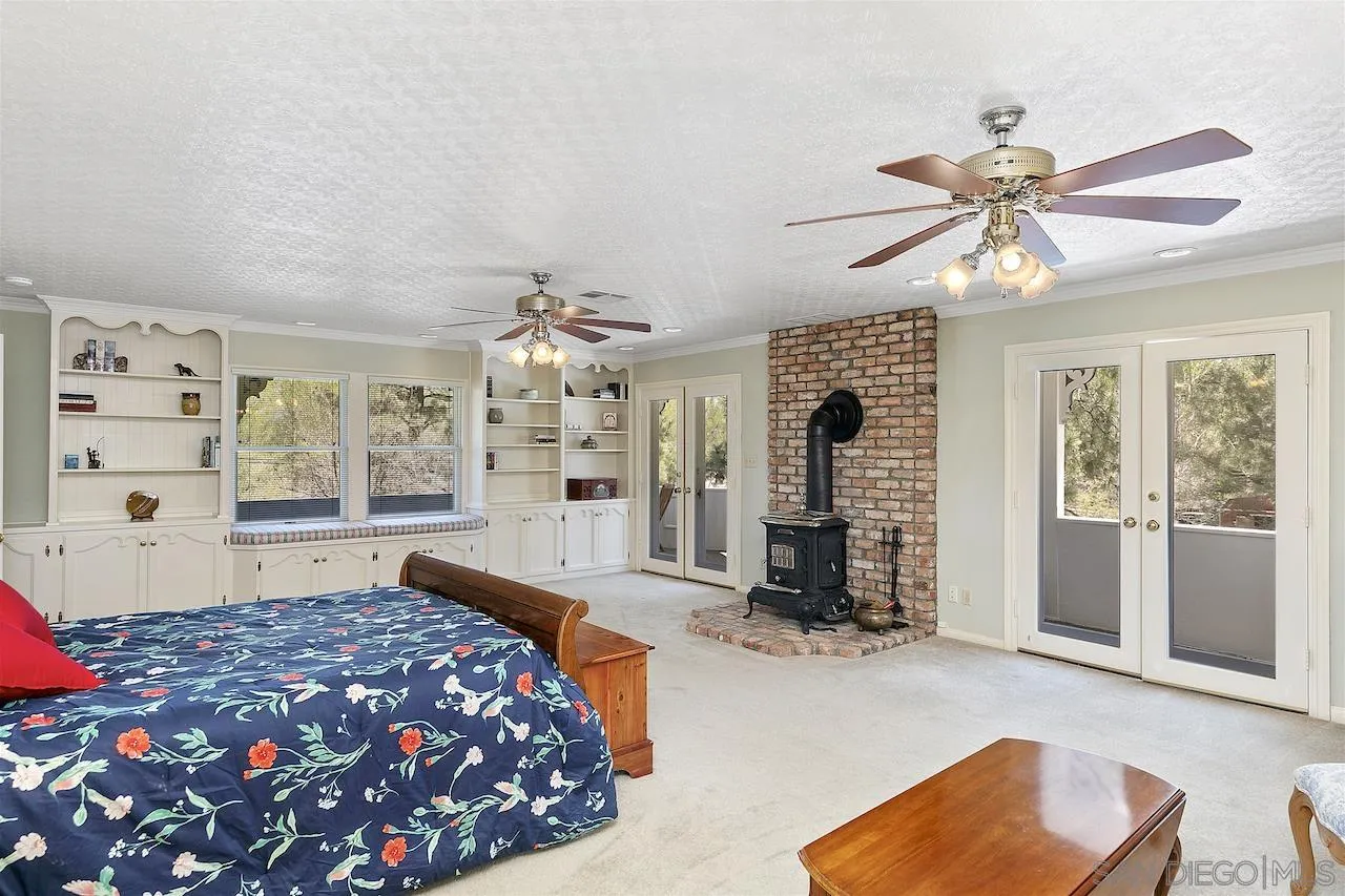 28659 Old Highway 80 Pine Valley, CA 91962 - Photo 24 of 55 a bedroom with a large bed and a chandelier