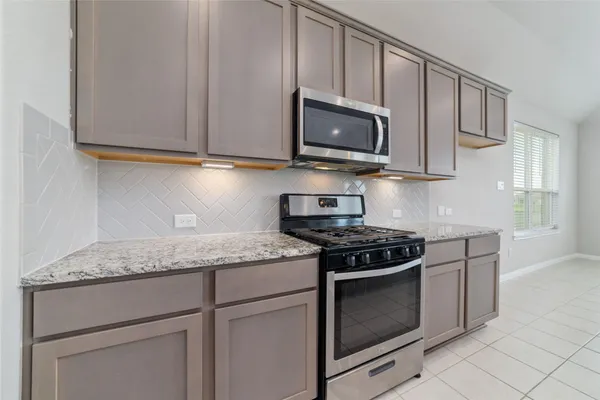 a kitchen with granite countertop white cabinets stainless steel appliances and a sink