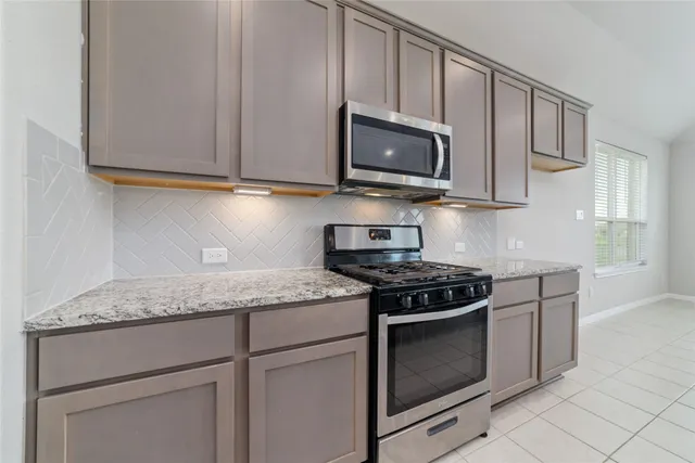 a kitchen with granite countertop white cabinets stainless steel appliances and a sink