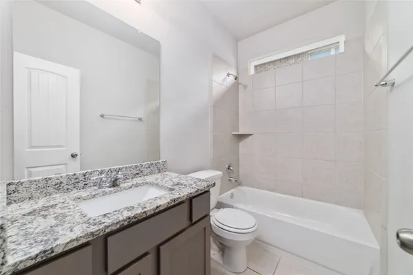 a bathroom with a granite countertop sink a toilet and bathtub