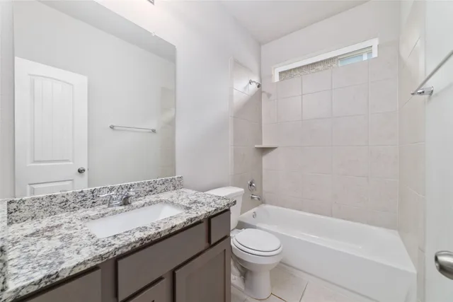 a bathroom with a granite countertop sink a toilet and bathtub