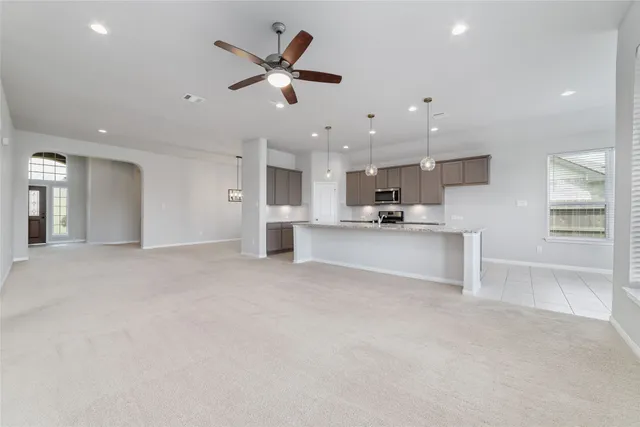 an open kitchen view with stainless steel appliances refrigerator oven and white cabinets with wooden floor