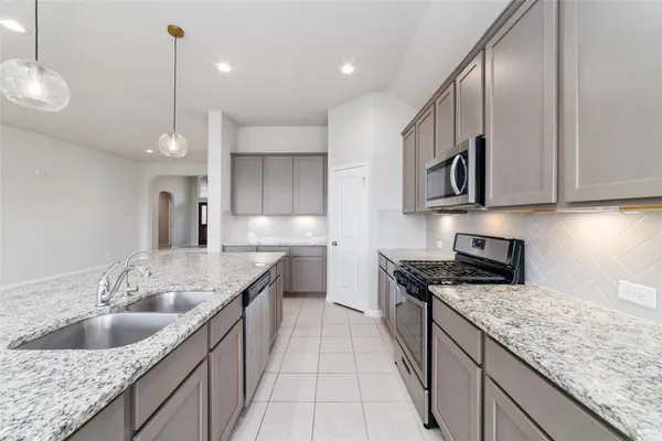 a kitchen with stainless steel appliances granite countertop a sink stove and cabinets