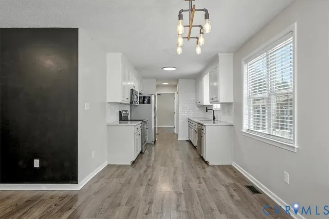 a view of a kitchen with a sink wooden floor and windows
