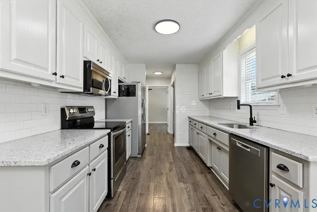 a large kitchen with stainless steel appliances granite countertop a stove a sink dishwasher and a refrigerator