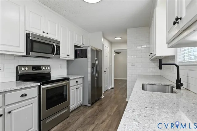 a kitchen with stainless steel appliances granite countertop a stove a microwave and a refrigerator