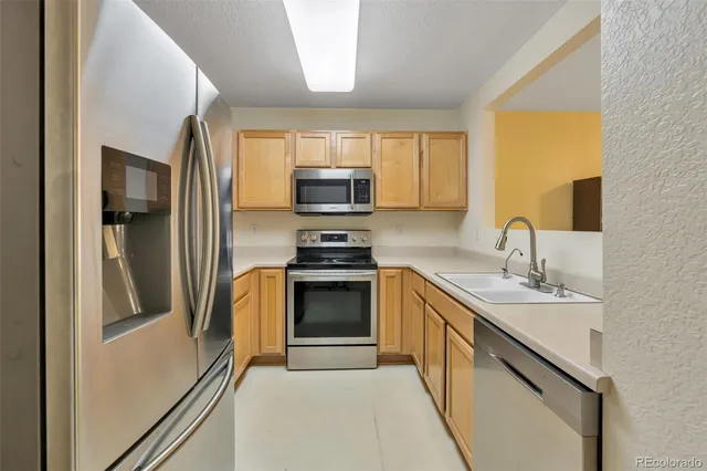 a kitchen with stainless steel appliances granite countertop a refrigerator sink and stove