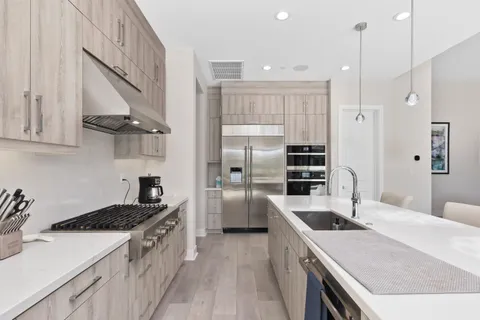 a kitchen with stainless steel appliances granite countertop a sink a stove and a refrigerator