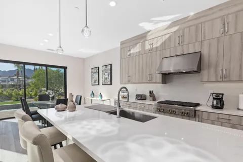 a kitchen with stainless steel appliances a sink a stove a microwave a center island and cabinets