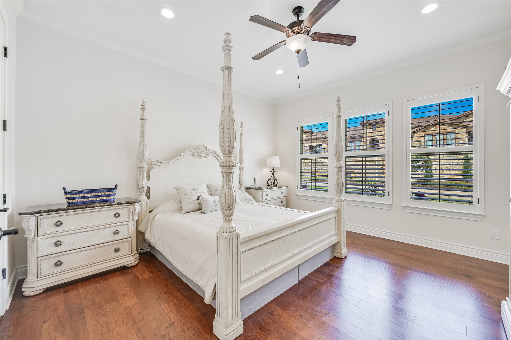 104-2 Rivalto Circle, Unit 1 Lakeway, TX 78734 - Photo 12 of 27 Primary Bedroom has wood floors, high ceilings, recessed lighting, plantation shutters, a ceiling fan, and recessed lighting