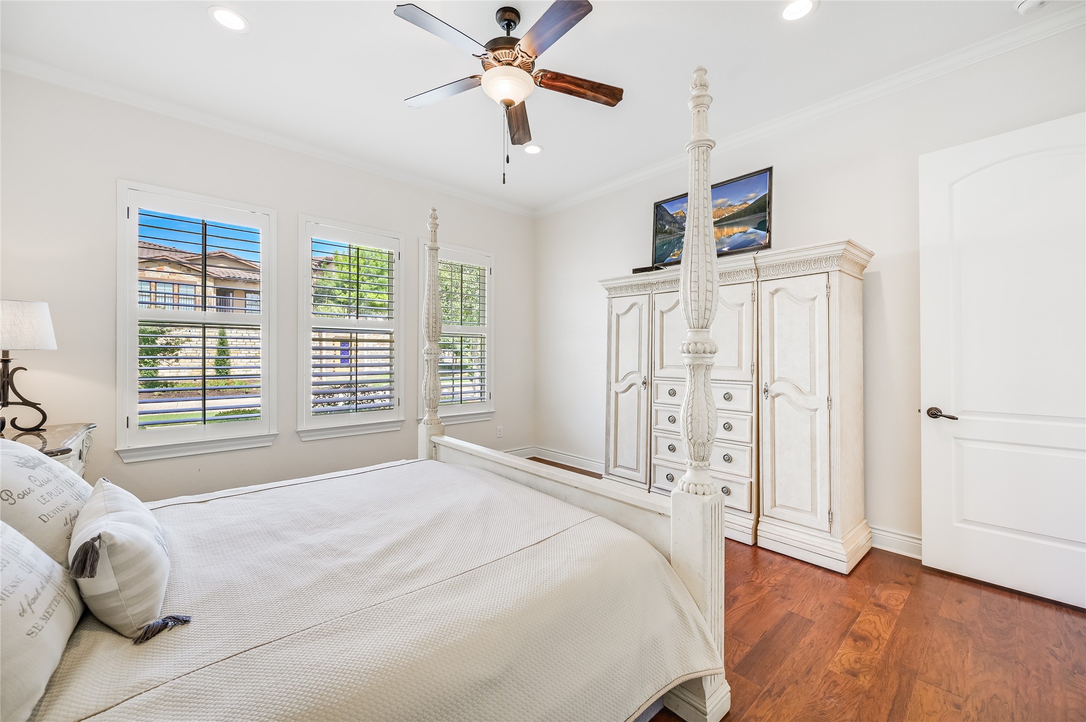 104-2 Rivalto Circle, Unit 1 Lakeway, TX 78734 - Photo 13 of 27 Primary Bedroom has wood floors, high ceilings, recessed lighting, plantation shutters, a ceiling fan, and recessed lighting