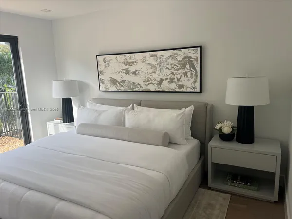 a bedroom with a bed and a painting on the wall