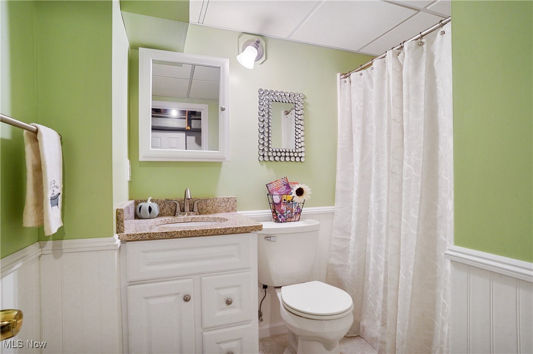 449 East Comet Road Clinton, OH 44216 - Photo 36 of 39 Bathroom featuring vanity, toilet, curtained shower, a paneled ceiling, and tile patterned flooring