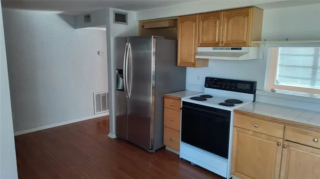 a kitchen with stainless steel appliances granite countertop a refrigerator and a stove