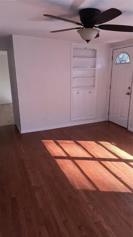 a view of a small space with wooden floor and a ceiling fan