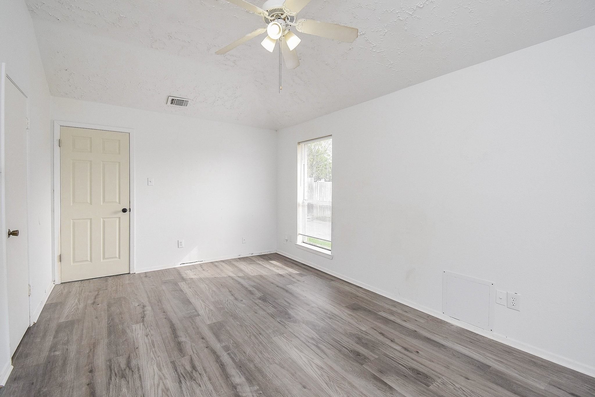 16330 Meadowbrook Farm Road Houston, TX 77082 - Photo 12 of 20 a view of an empty room with wooden floor and a ceiling fan